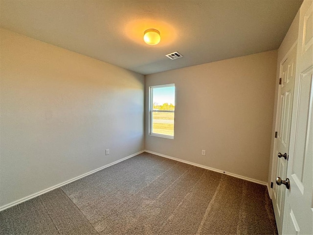 empty room featuring dark colored carpet