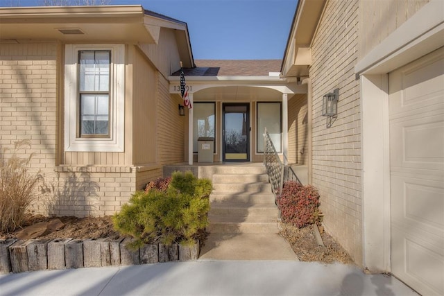 property entrance featuring covered porch and a garage