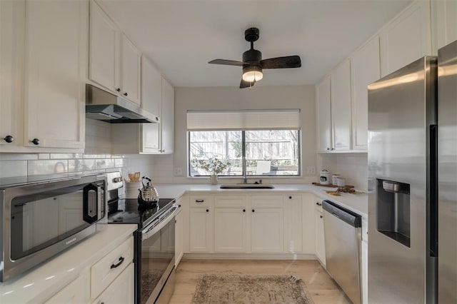 kitchen featuring light hardwood / wood-style flooring, decorative backsplash, white cabinets, appliances with stainless steel finishes, and ceiling fan