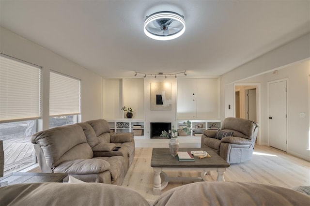 living room with rail lighting, ceiling fan, and a large fireplace