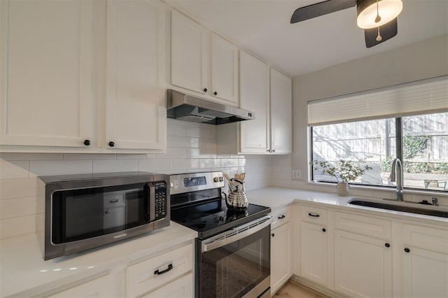 kitchen featuring appliances with stainless steel finishes, white cabinetry, and sink