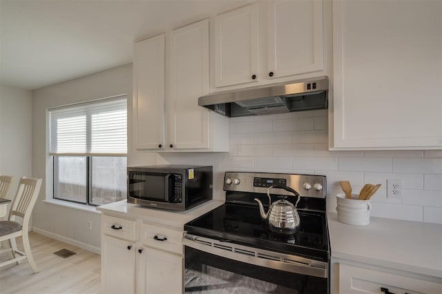 kitchen featuring stainless steel electric range, white cabinetry, tasteful backsplash, and light hardwood / wood-style floors