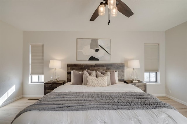 bedroom featuring multiple windows, ceiling fan, and light hardwood / wood-style flooring