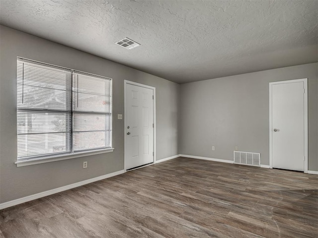 spare room with wood-type flooring and a textured ceiling