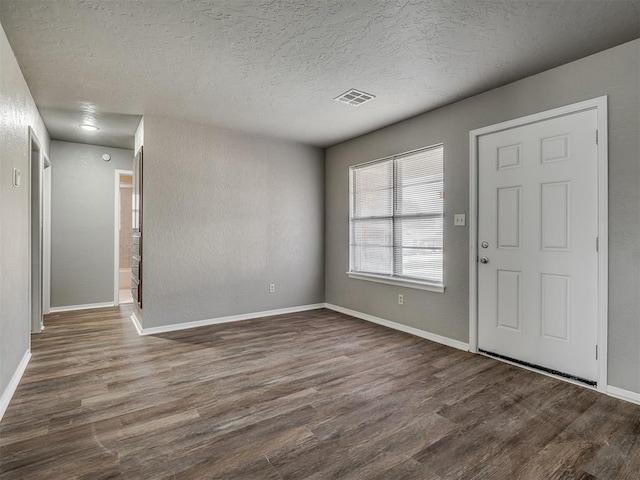 foyer with a textured ceiling and dark hardwood / wood-style floors