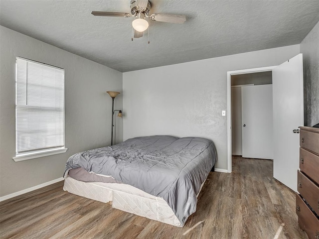 bedroom with wood-type flooring, a textured ceiling, and ceiling fan