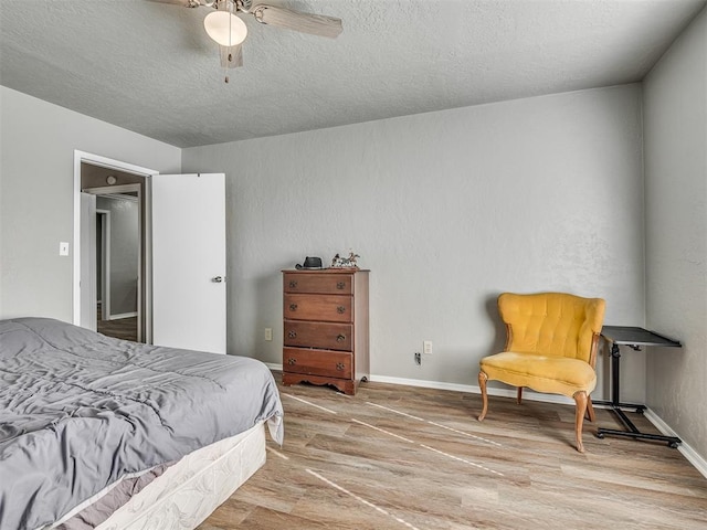 bedroom with hardwood / wood-style flooring, ceiling fan, and a textured ceiling