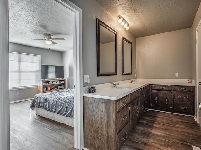 bathroom with hardwood / wood-style floors, vanity, a textured ceiling, and ceiling fan