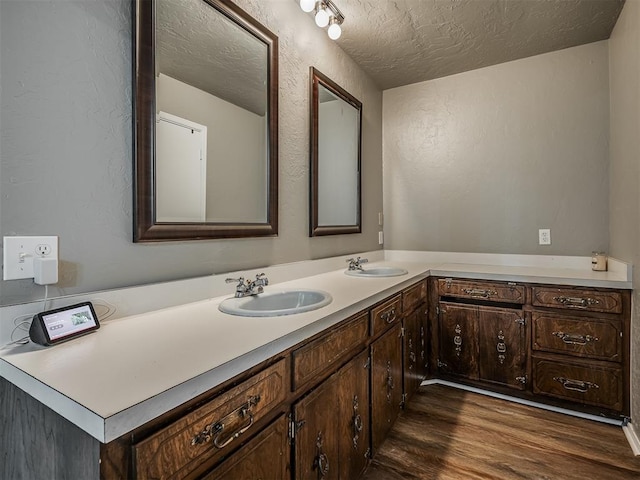 bathroom featuring vanity, wood-type flooring, and a textured ceiling