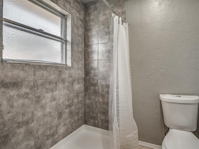 bathroom featuring a shower with shower curtain and toilet