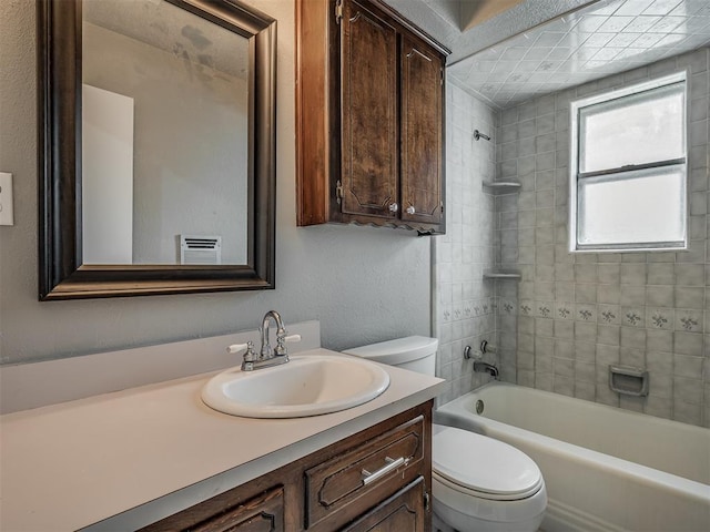 full bathroom with vanity, tiled shower / bath combo, and toilet