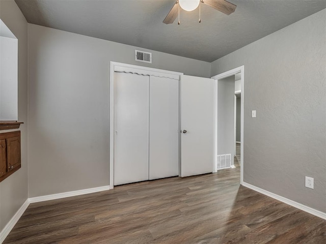 unfurnished bedroom featuring ceiling fan, a closet, and hardwood / wood-style floors