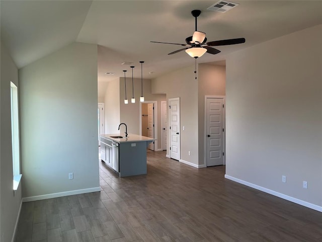 kitchen featuring vaulted ceiling, ceiling fan, sink, a center island with sink, and hanging light fixtures