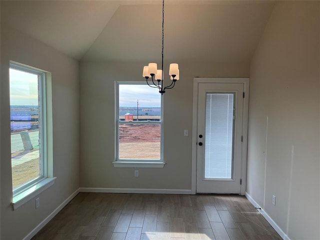 interior space with vaulted ceiling, an inviting chandelier, and a wealth of natural light