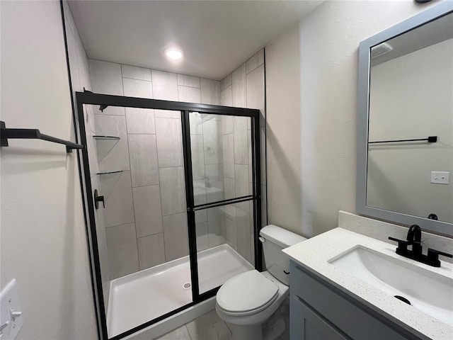 bathroom with vanity, a shower with shower door, and toilet