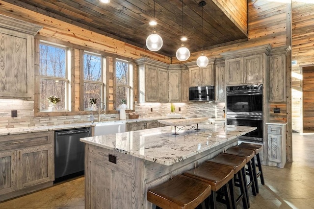 kitchen with a center island, dishwasher, double oven, light stone counters, and sink