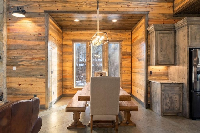 dining area with wood ceiling, a notable chandelier, and wooden walls