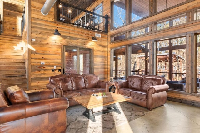 living room featuring a high ceiling and wooden walls