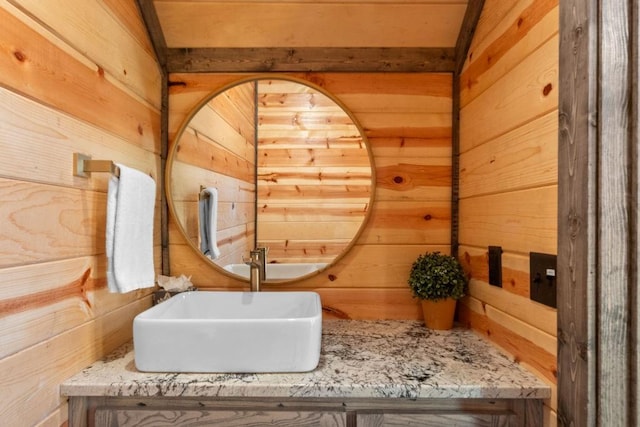 bathroom with sink and wooden walls