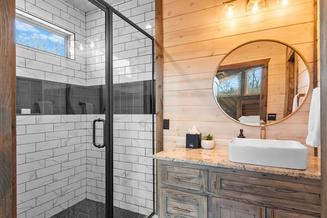 bathroom featuring walk in shower, vanity, and wooden walls