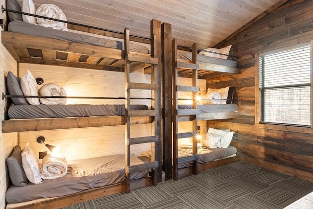 unfurnished bedroom featuring vaulted ceiling, wood ceiling, and wooden walls