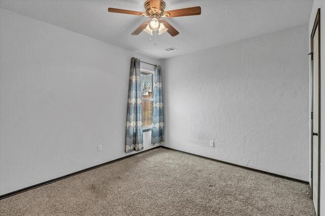 spare room with carpet floors and ceiling fan