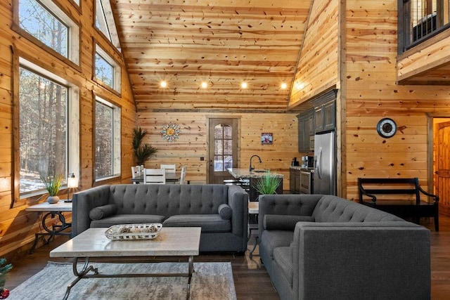 living room with wood walls, wooden ceiling, dark hardwood / wood-style floors, high vaulted ceiling, and sink