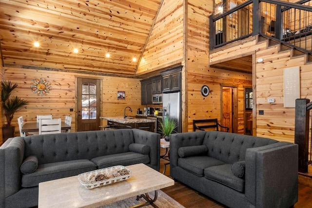 living room with wood walls, wooden ceiling, dark hardwood / wood-style floors, high vaulted ceiling, and sink