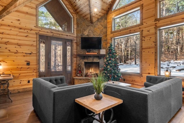 living room with high vaulted ceiling, wood ceiling, wood walls, and light hardwood / wood-style flooring