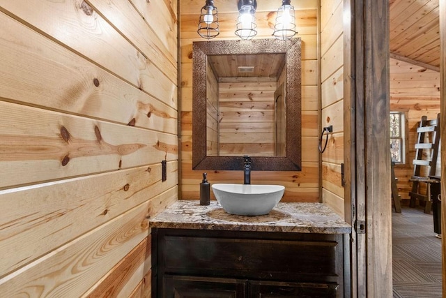 bathroom featuring wooden ceiling, vanity, and wood walls