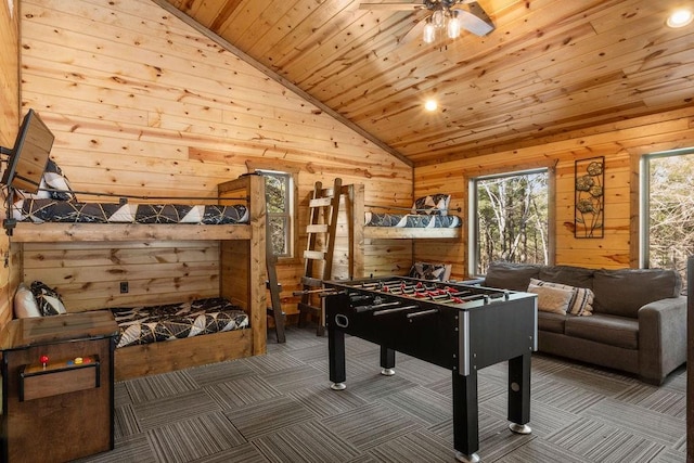 recreation room with wood ceiling, wood walls, and dark carpet