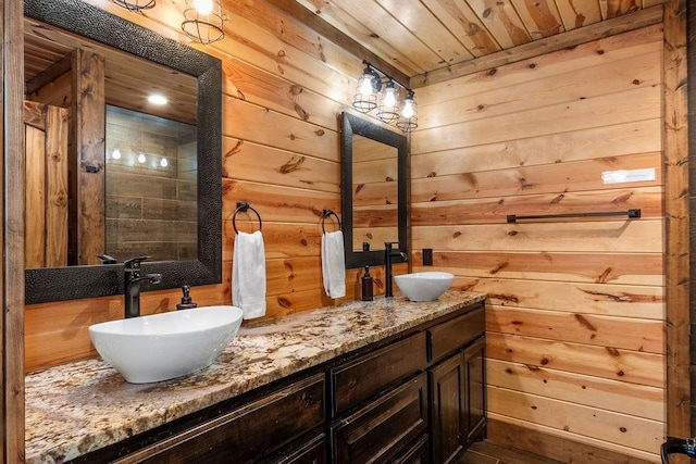 bathroom featuring vanity, wooden walls, and wooden ceiling