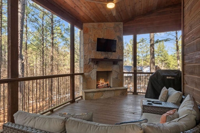 unfurnished sunroom featuring vaulted ceiling, wood ceiling, and an outdoor stone fireplace