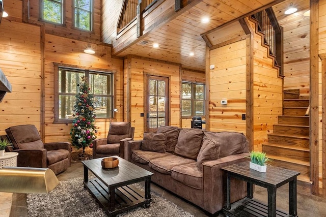 living room featuring a high ceiling, wood ceiling, and wood walls