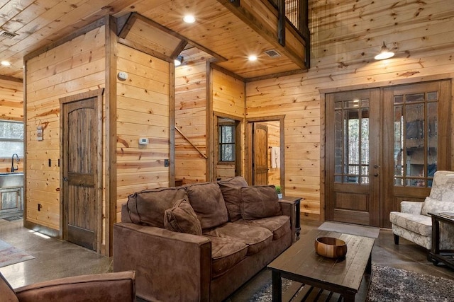 living room with wooden ceiling, a towering ceiling, and wood walls