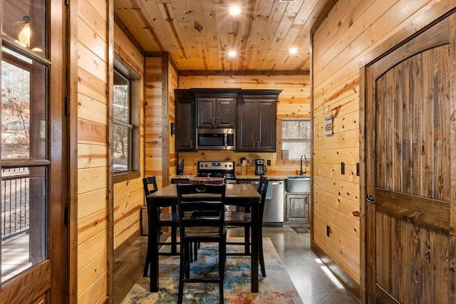 dining room featuring wooden ceiling and wood walls