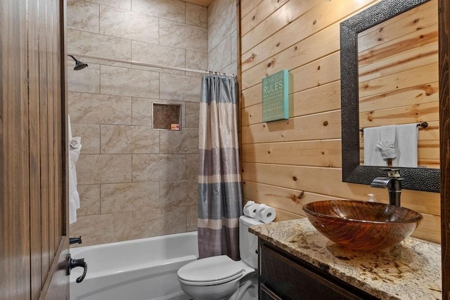 full bathroom featuring vanity, toilet, wooden walls, and shower / tub combo with curtain