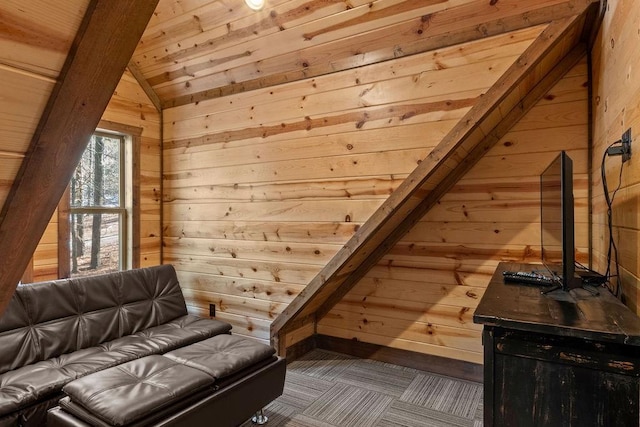 living area featuring lofted ceiling, wooden walls, and wooden ceiling