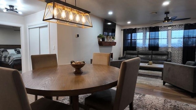 dining space with ceiling fan and wood-type flooring