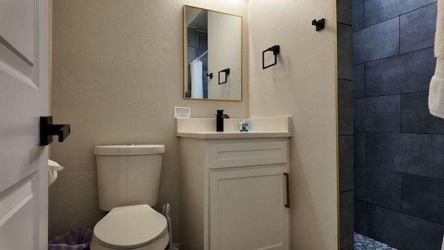 bathroom featuring a shower, toilet, and vanity