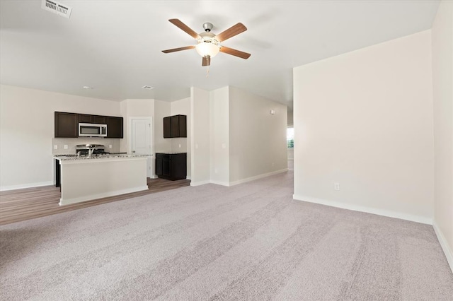 unfurnished living room with ceiling fan and light carpet