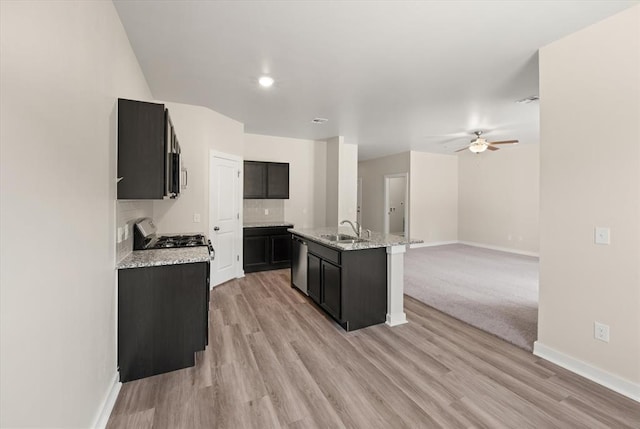 kitchen with dishwasher, a kitchen island with sink, sink, ceiling fan, and range