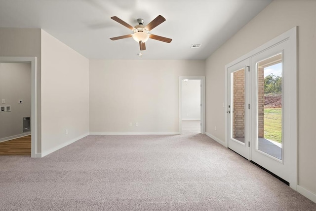 spare room featuring ceiling fan and light carpet