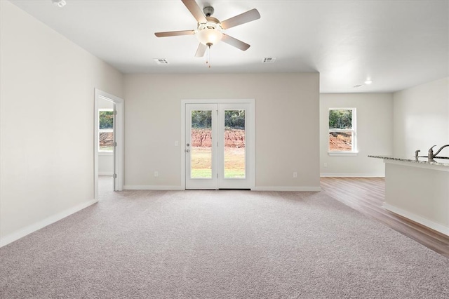 empty room featuring ceiling fan, light colored carpet, and sink