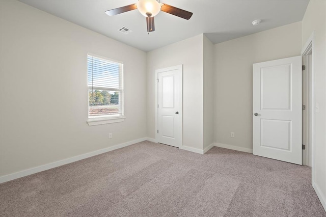 unfurnished room featuring ceiling fan and light carpet