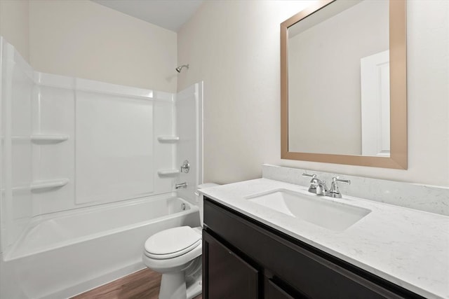 full bathroom featuring vanity, washtub / shower combination, wood-type flooring, and toilet