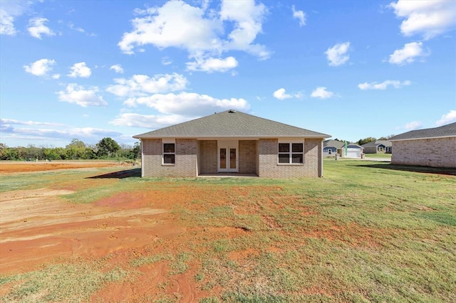 back of property with a lawn and french doors