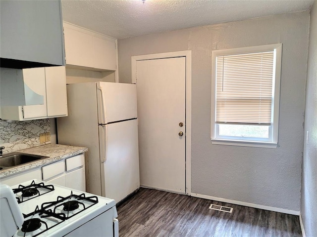 kitchen with sink, white appliances, white cabinetry, and a textured ceiling