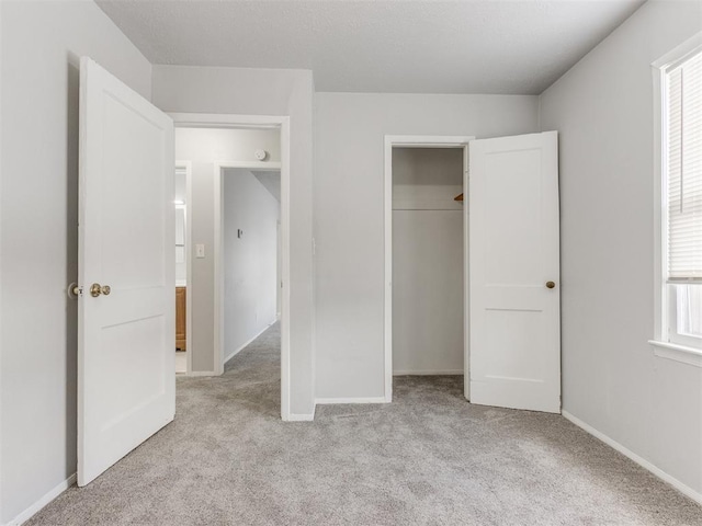 unfurnished bedroom featuring a closet and light carpet