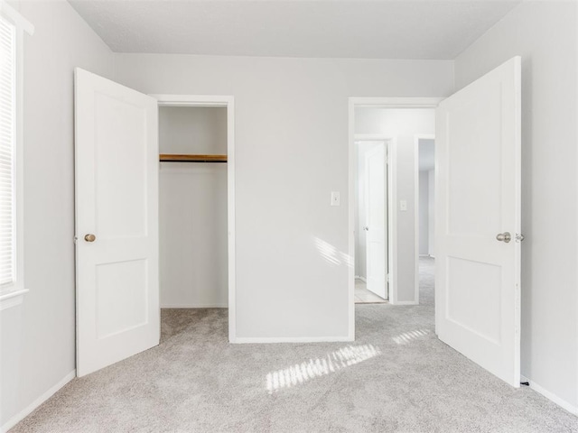 unfurnished bedroom featuring a closet and light carpet